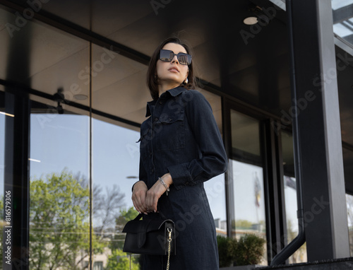 stylish, trendy modern women advertising sunglasses, dressed in modern outfits.girl against his building with large windows.female wear a hat, face close up, portrait.sun eye protection,uv rays