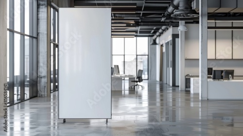 Modern office interior with a blank white roll-up banner, spacious workspace, and large windows