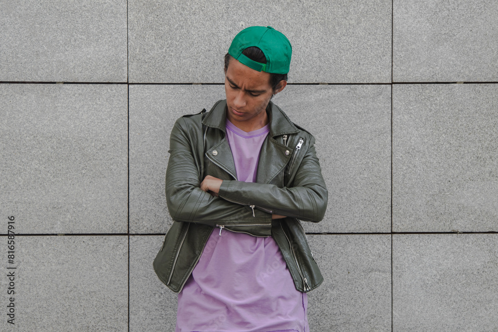 depressed and lonely urban young man leaning on the wall in the street
