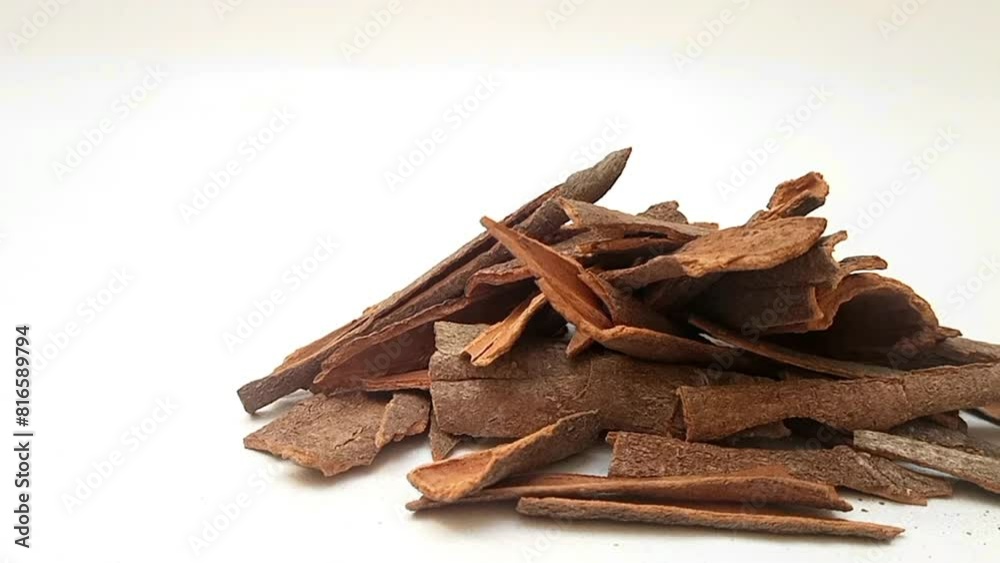 Pile of Cinnamon sticks on white background isolated, moving from right to left, front view, close up, herbs and spices