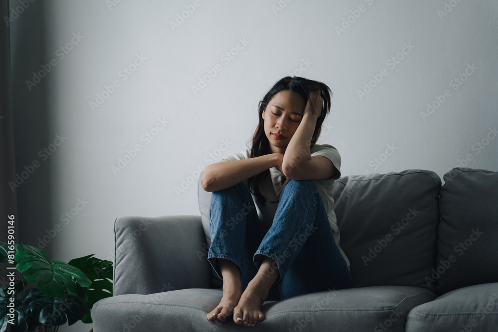 Unhappy lonely depressed woman is sitting on the couch and holding her head. Unhappy lonely depressed woman is sitting on the couch and holding her head.