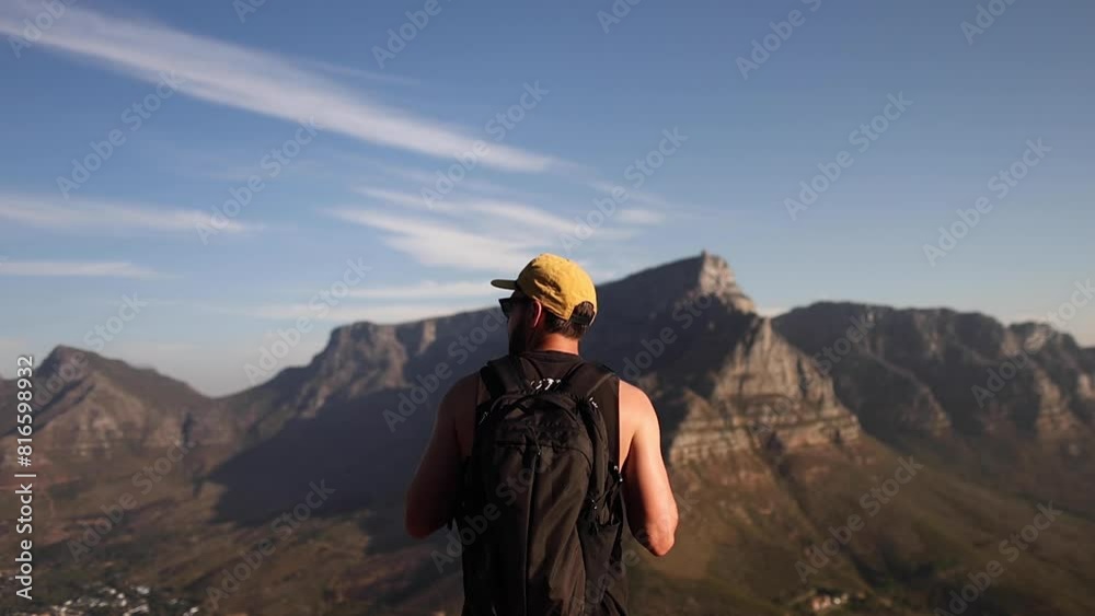 Man standing on mountain looking at landscape Man standing on mountain looking at landscape