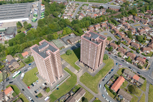 Aerial drone photo of the town of Bramley which is a district in west Leeds, West Yorkshire, England UK, showing residential housing estates, and two blocks of flats and apartments in the summer time
