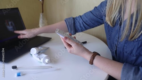 Toothpaste ingredients. Girl checks composition of toothpaste and is surprised by dangerous composition of product. Emulsifiers, preservatives, dyes, PEG, SLS, parabens, diethanolamine photo