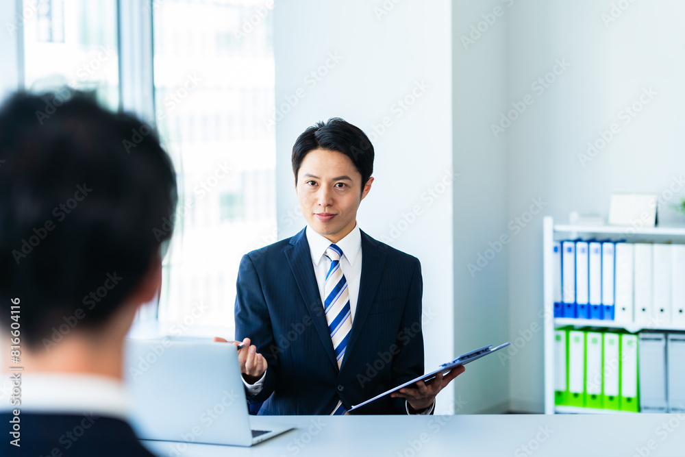 オフィスで面談するビジネスパーソン オフィスで面談するビジネスパーソン