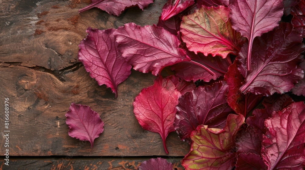 Obraz premium Beetroot leaves on a brown wooden surface