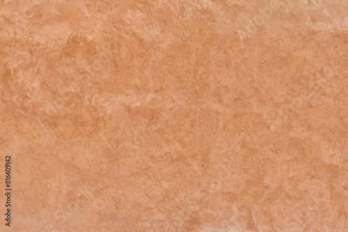 Unevenly painted terracotta-colored plastered wall