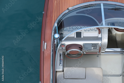 Control panel of the speed-boat luxury wooden boat top view against the background of water. Top view of a wooden expensive exclusive boat. Varnished wooden boat on a background of water.