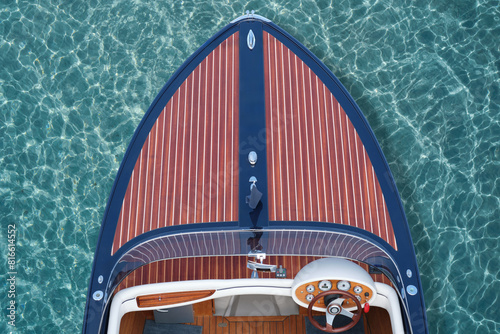 Control panel of the speed-boat luxury wooden boat top view on a background of blue transparent water. Top view of a wooden expensive exclusive boat.