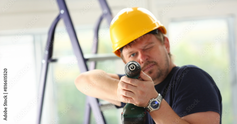 Arms of worker using electric drill closeup. Manual job DIY inspiration improvement job fix shop yellow helmet joinery startup idea industrial education profession career concept Arms of worker using electric drill closeup. Manual job DIY inspiration improvement job fix shop yellow helmet joinery startup idea industrial education profession career concept