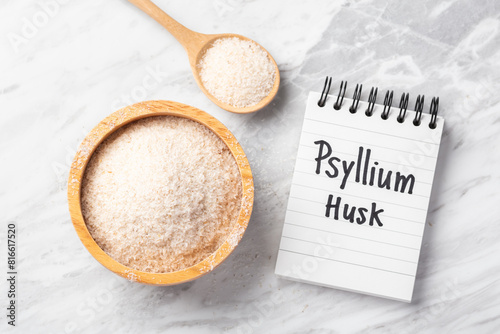 Psyllium husk in wooden bowl with psyllium husk word on notebook on marble kitchen table