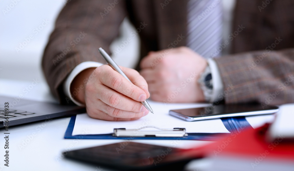 Male arm in suit and tie hold silver pen filling schedule in notepad at office workplace closeup. Legal law consult assistance gesture or finance investment advisor clerk job information gesture Male arm in suit and tie hold silver pen filling schedule in notepad at office workplace closeup. Legal law consult assistance gesture or finance investment advisor clerk job information gesture