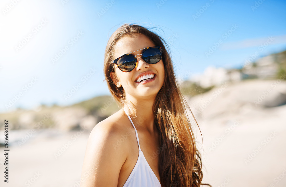 Portrait, beach and woman with sunglasses, excited and smile with happiness, holiday and weekend break. Face, person and girl with eyewear, seaside and vacation with getaway trip, travel and sunshine