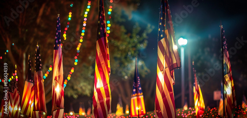 Brightly lit flags wave during the night at a Veterans Day parade with vibrant lighting.