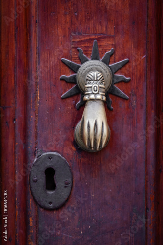 Brass door knocker in the shape of a hand.