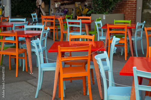 Colorful chairs and tables in a street cafe in Europe .