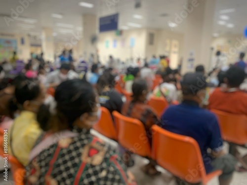 Blurry image of many patients coming to use the hospital's services and waiting to see a doctor.
