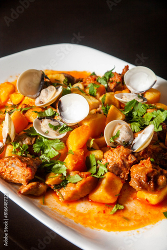 Traditional Portuguese dish: Pork Alentejana. Tender pork marinated in spices, served with clams and potatoes. Authentic taste of Portugal. photo