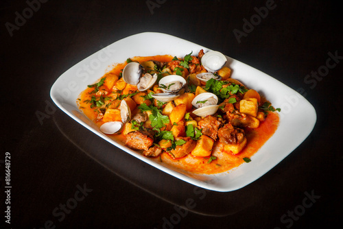 Traditional Portuguese dish: Pork Alentejana. Tender pork marinated in spices, served with clams and potatoes. Authentic taste of Portugal. photo