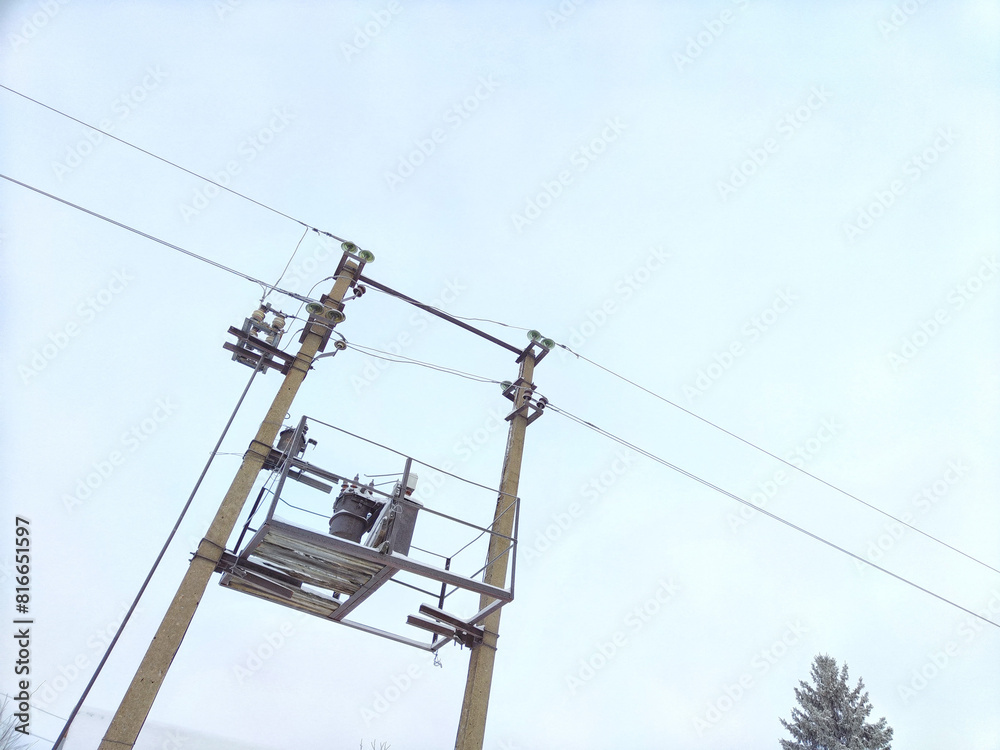 Old power line pole and transformer against blue sky in sunny day Old power line pole and transformer against blue sky in sunny day