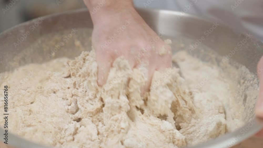 Closeup on hands kneading yeast dough in the metal bowl Closeup on hands kneading yeast dough in the metal bowl