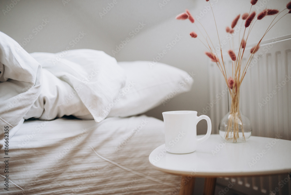 White cup of coffee on the table of bedroom White cup of coffee on the table of bedroom