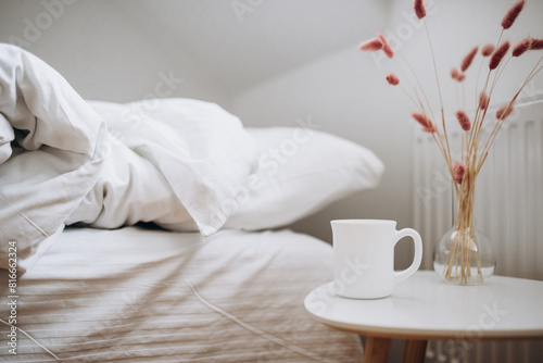 White cup of coffee on the table of bedroom