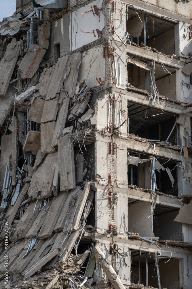 Close-up of a ruined multi-story building with exposed structural elements, depicting urban decay, destruction, and the aftermath of a demolition or natural disaster. Close-up of a ruined multi-story building with exposed structural elements, depicting urban decay, destruction, and the aftermath of a demolition or natural disaster.
