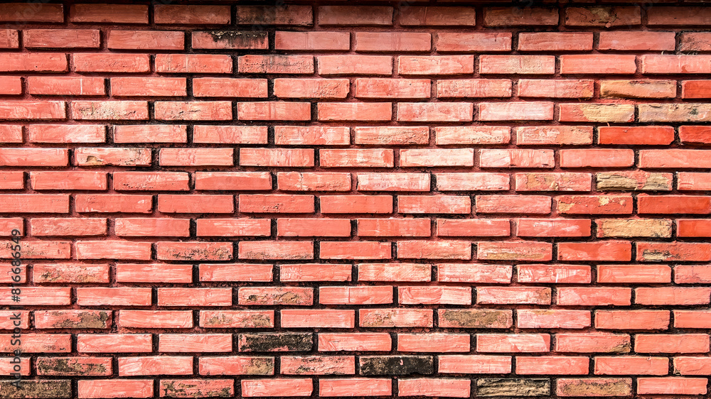 Obraz premium Close-up of a brick wall with signs of wear and tear, with chipping paint and faded colors