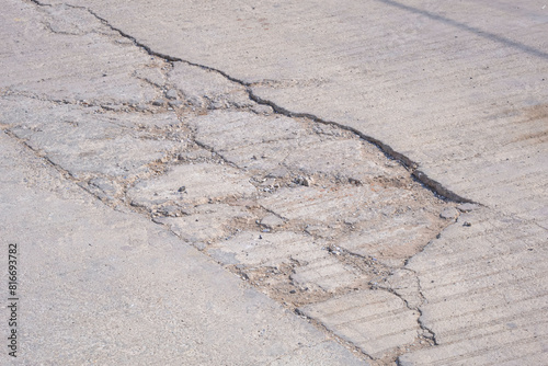 Cracks and broken texture with collapse of the old badly damaged concrete street surface