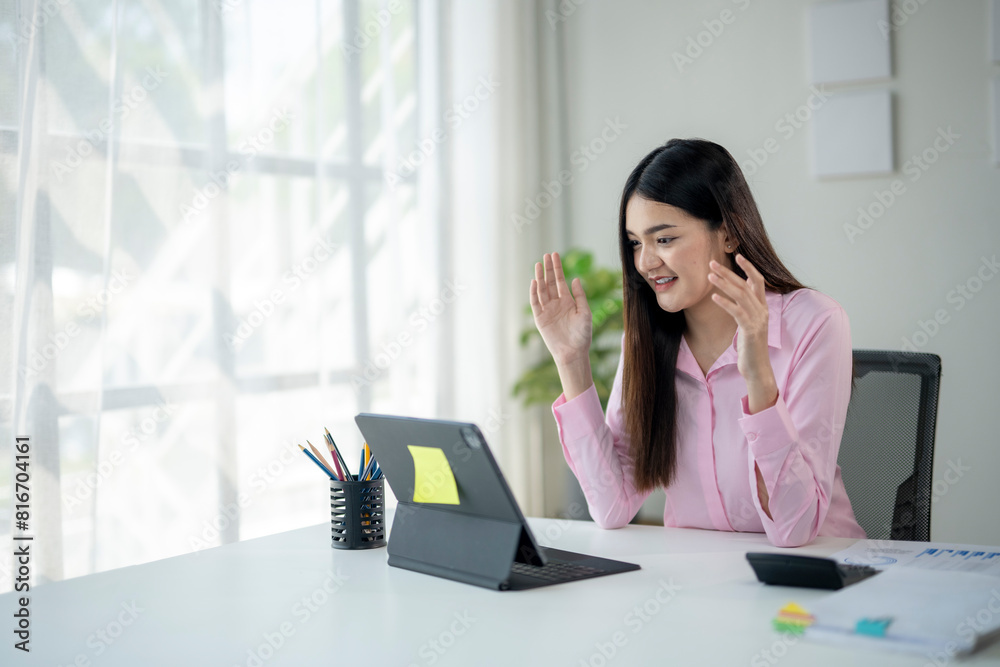 A woman is sitting at a desk with a computer and a keyboard A woman is sitting at a desk with a computer and a keyboard
