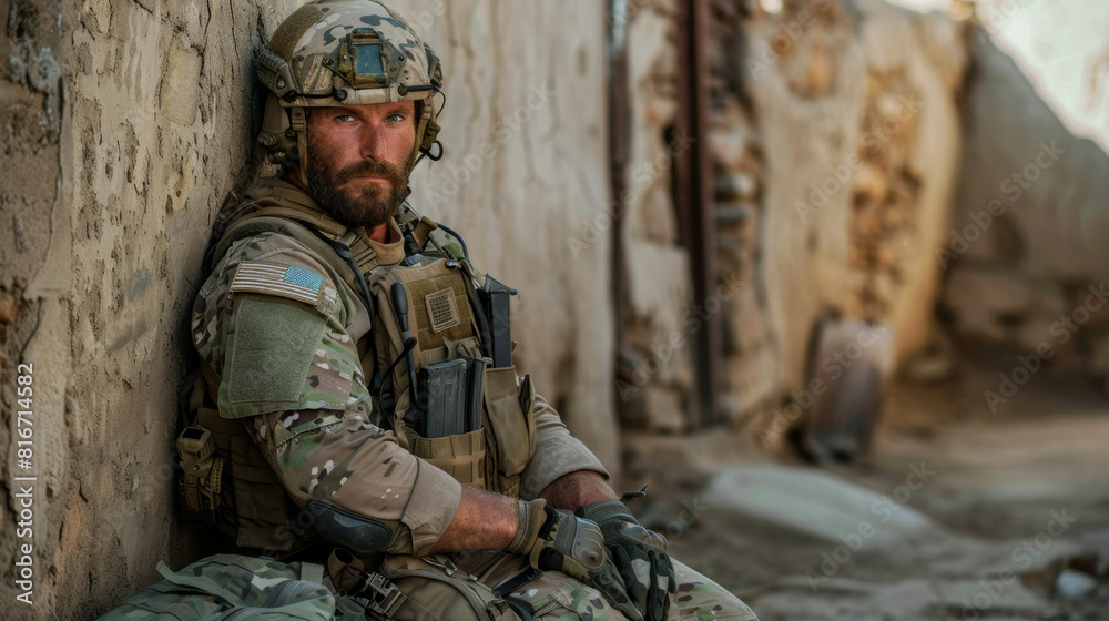 A portrait of a resolute american soldier in full gear, posing with his rifle against a wall A portrait of a resolute american soldier in full gear, posing with his rifle against a wall