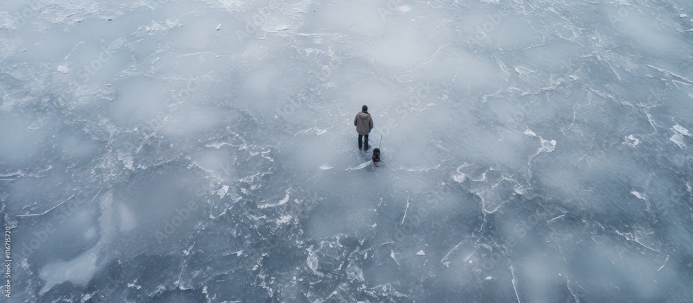 View from above of a fisherman standing on the thin ice of a frozen lake wearing warm shoes and holding a fishing rod with a pit nearby Difficult to recognize Copy space image 150