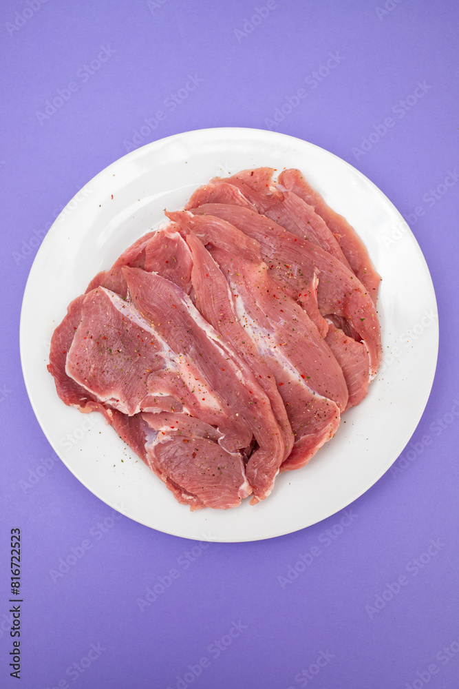 Raw turkey fillet, Poultry meat on white plate. Top View.
