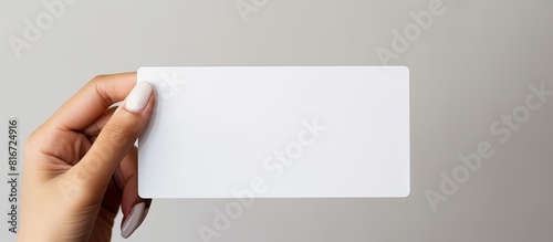 A white prepaid card is held by a woman s hand against a white background with ample empty space for additional images or text