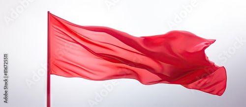 A red flag flutters with a lively motion against a clean white backdrop providing ample empty space for additional images