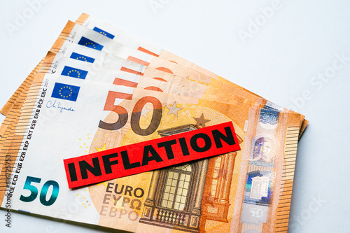 Euro banknotes background, with red ticket with text Inflation.
