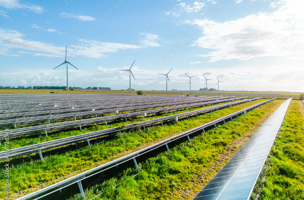Wind turbines and solar panels farm in a field. Renewable green energy ...