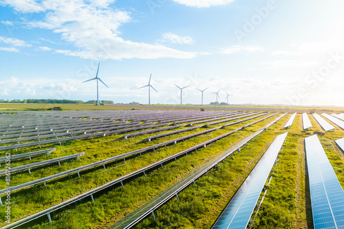 Wind turbines and solar panels farm in a field. Renewable green energy. Sunny landscape, electric energy generator for clean energy producing concept. Solar panels and wind power generation equipment