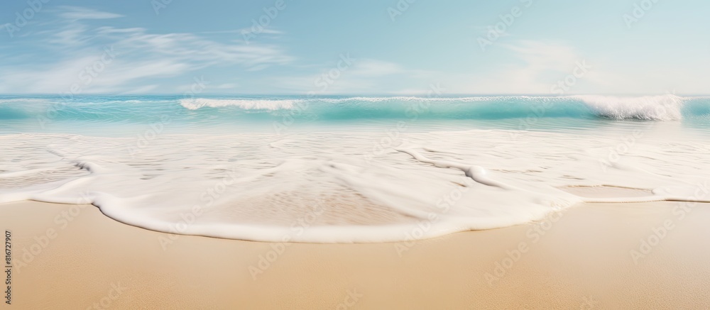 A sandy beach with a gentle sea wave in the background creating a soft foam There is empty space for additional elements in the image