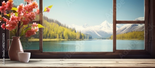 A sunny warm day creates a peaceful landscape with a retro brown window sill in the background The sill offers free space for personalized decoration and the scene showcases a spring lake and mountai photo