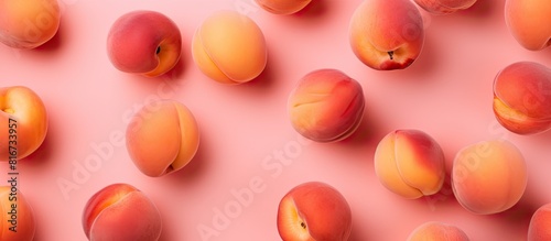 The copy space image showcases a fresh apricot on a vibrant pink background creating a contemporary summer pattern in a flat lay style