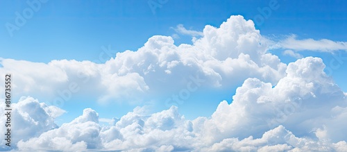 A copy space image of a spacious blue sky with fluffy clouds stretching across the horizon