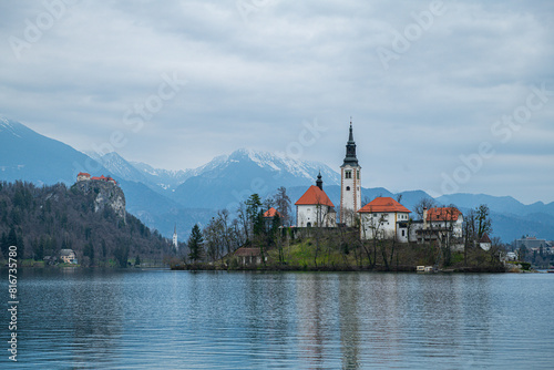 Scenic view of a church on an island in a tranquil lake on a cloudy day