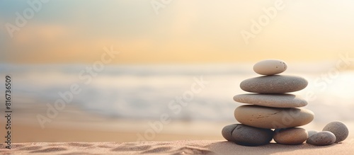 A stack of spa stones placed on a sandy background with ample copy space for images