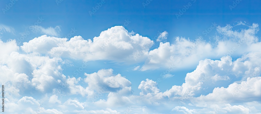 The image shows a wide expanse of clear blue sky with fluffy white clouds. with copy space image. Place for adding text or design The image shows a wide expanse of clear blue sky with fluffy white clouds. with copy space image. Place for adding text or design