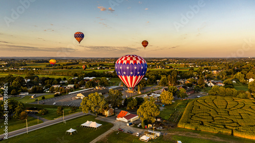 Aerial View of Multiple Hot Air Balloons Floating Away in Rural Pennsylvania at Sunrise photo