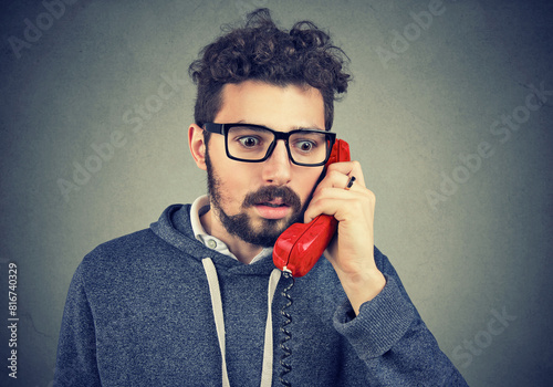 Portrait of an anxious young man receiving bad news on a phone 