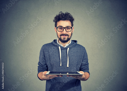 Handsome hipster guy with a tablet computer looking at camera   photo