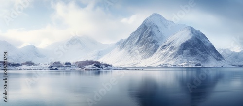 A serene winter view of Vestvagoy island with a snow covered peak on the Lofoten Islands following a heavy snowfall creating a captivating seascape on the Norwegian sea A picturesque copy space image photo